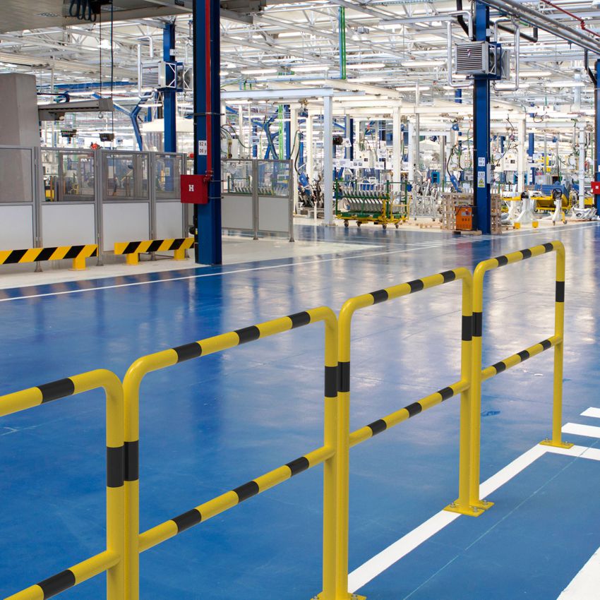 Das Bild zeigt einen Rammschutzbügel mit Knieholm in Verkehrsgelb zur Absicherung einer Durchfahrt in einer Industriehalle.
