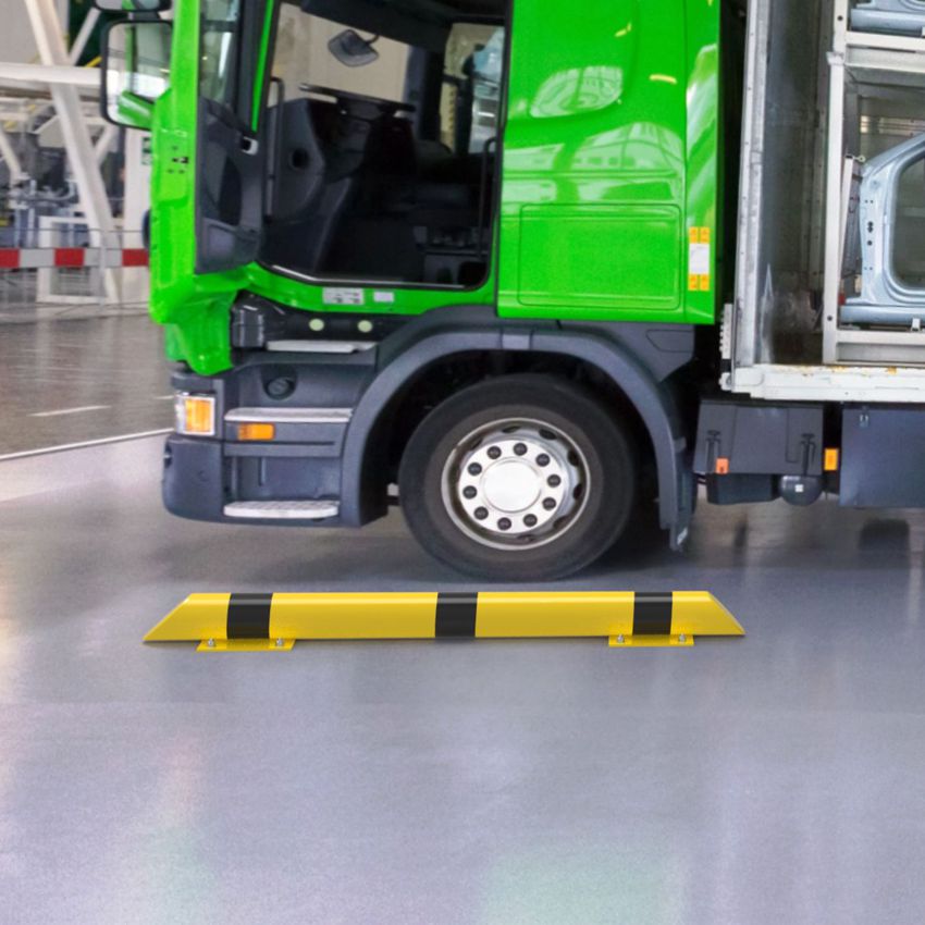 Extra robuster, gelb-schwarzer Rammschutzbalken als Begrenzungshilfe für Lkw in einer Industriehalle.